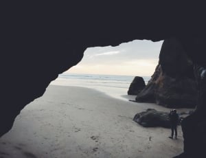 man inside of the cave during daytime thumbnail