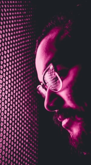 man in eyeglasses leaning on purple window thumbnail