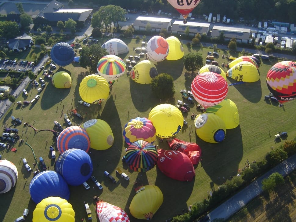 photo of hot air balloons and people on the open ground from top view preview