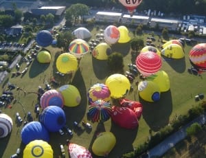 photo of hot air balloons and people on the open ground from top view thumbnail