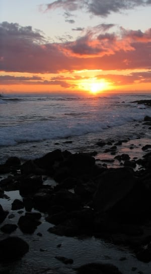 sunset over rocky beach thumbnail