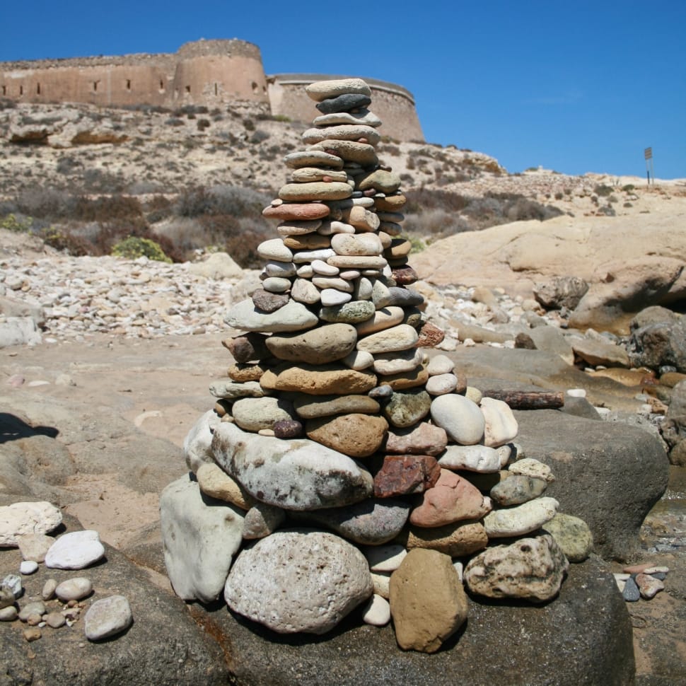 pebbles arranged as tower on gray rock during daytime preview