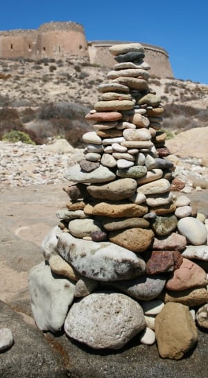 pebbles arranged as tower on gray rock during daytime thumbnail