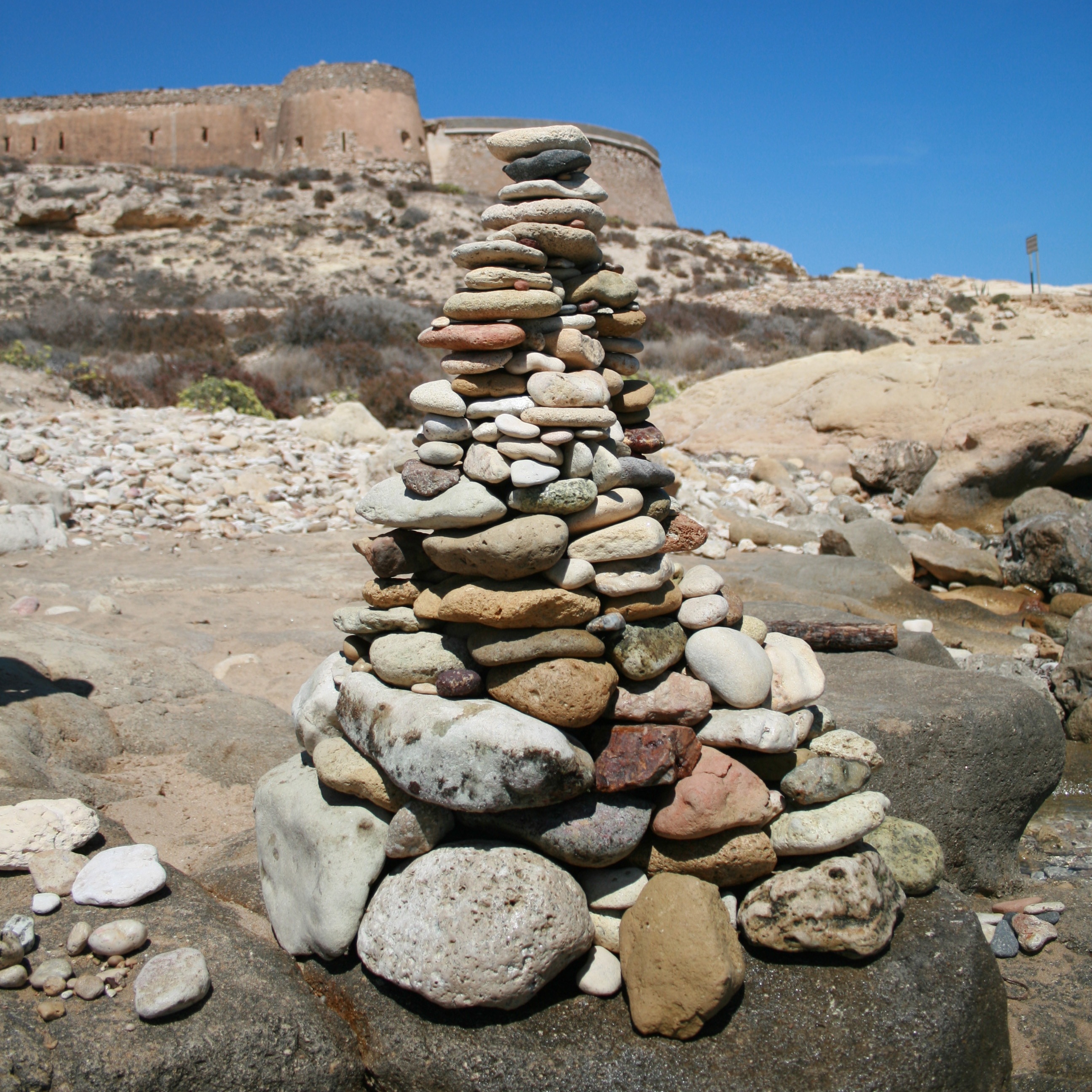 pebbles arranged as tower on gray rock during daytime
