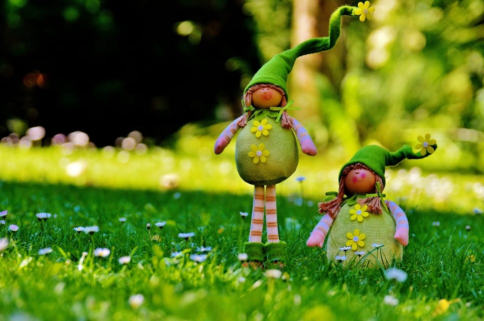 doll in green dress standing on grass during daytime preview