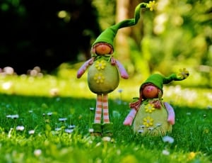 doll in green dress standing on grass during daytime thumbnail