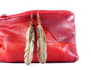 red leather purse and pair of gold dangling feather earrings thumbnail
