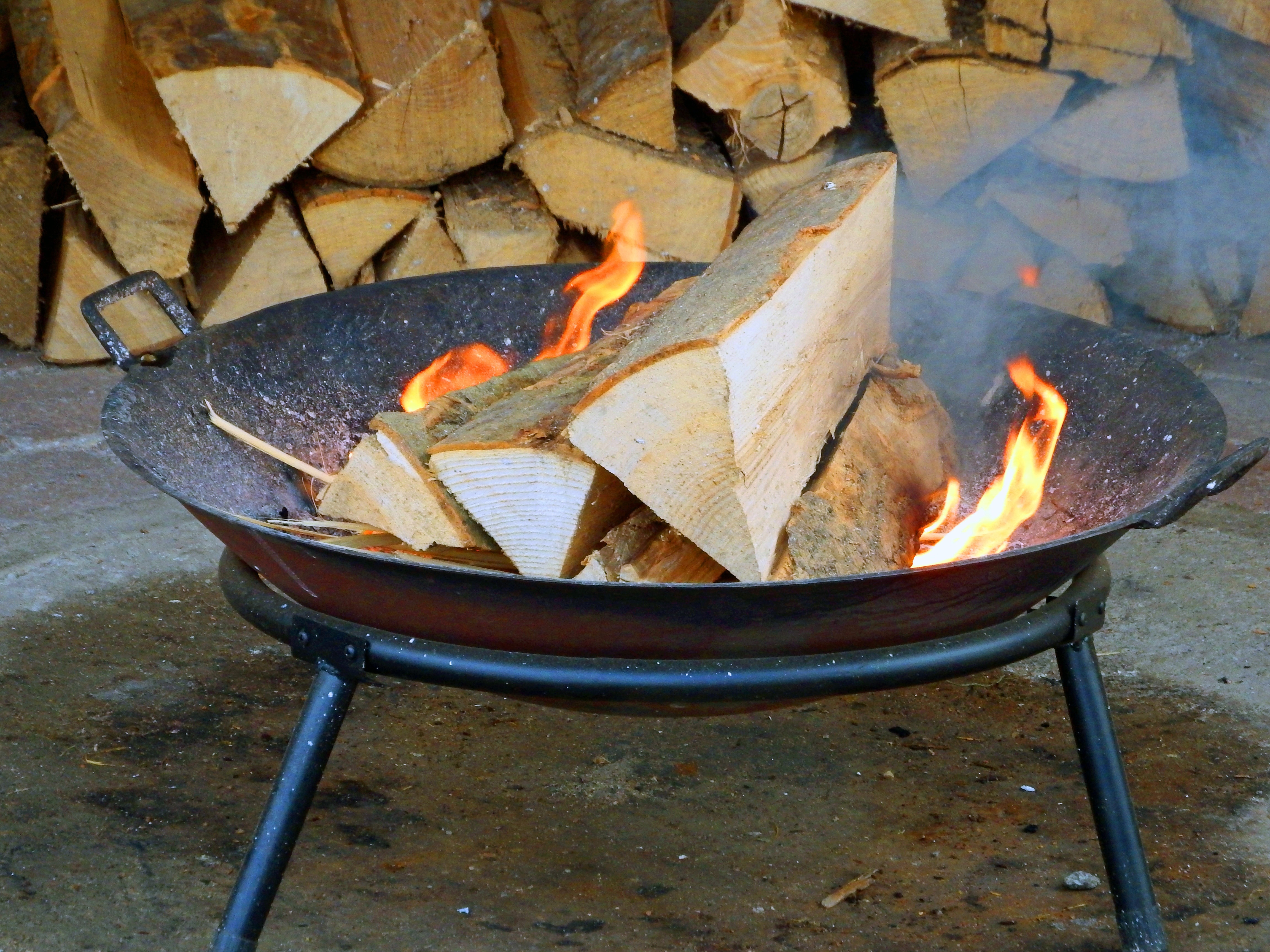wood logs on fire in black wok