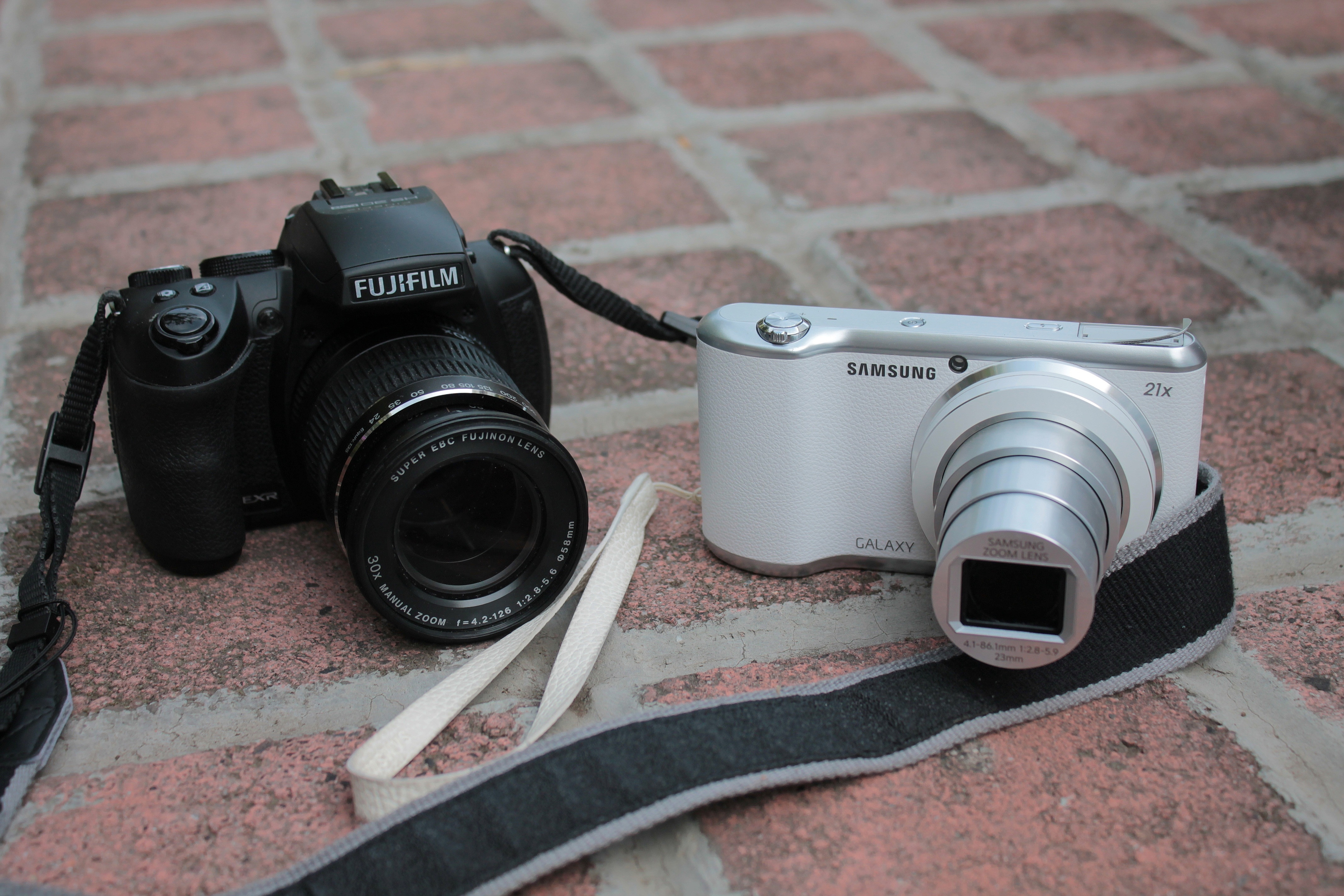 two black Fujifilm and white Samsung cameras