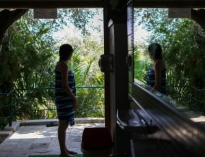 woman standing near door and veranda with mirror reflection thumbnail