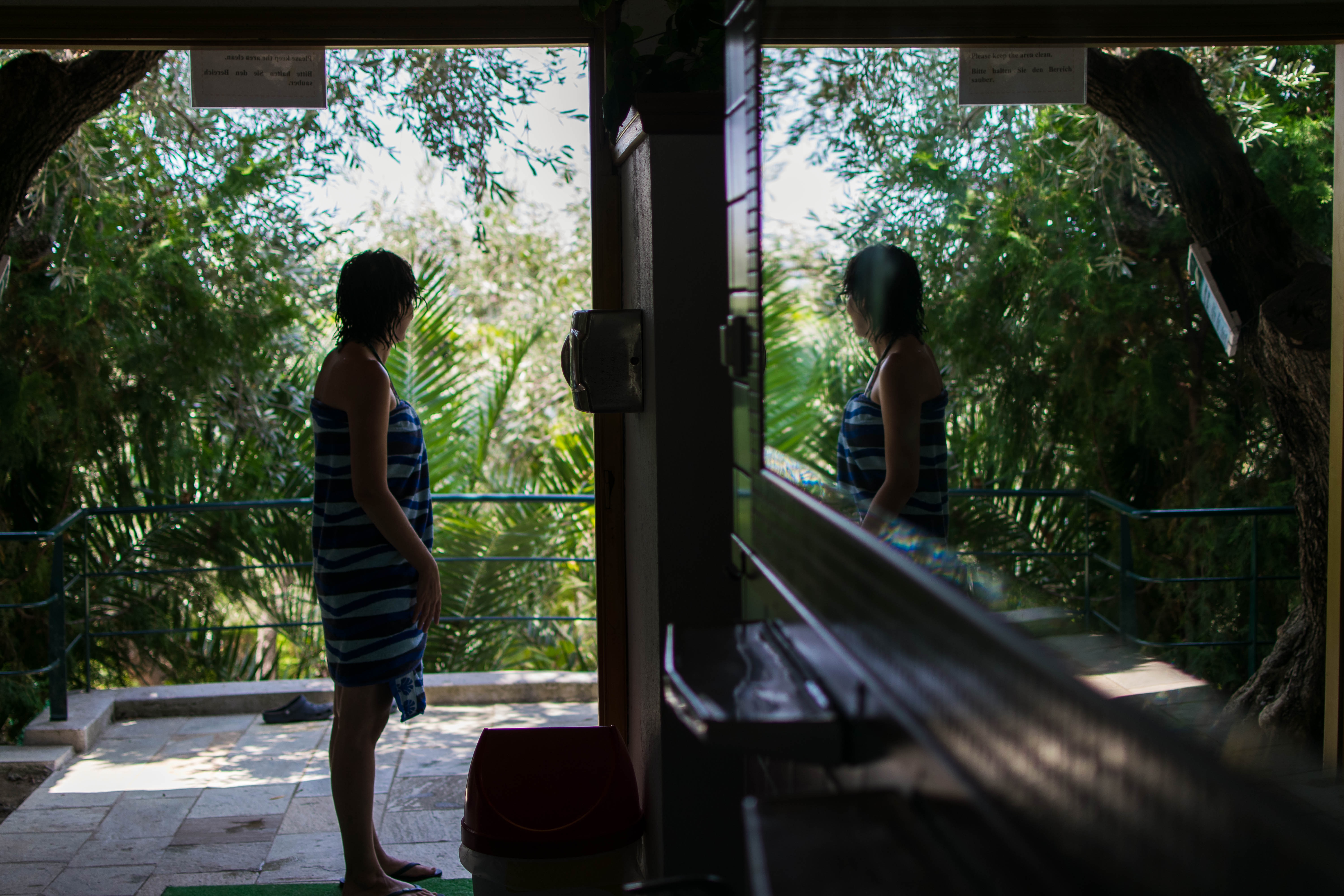 woman standing near door and veranda with mirror reflection