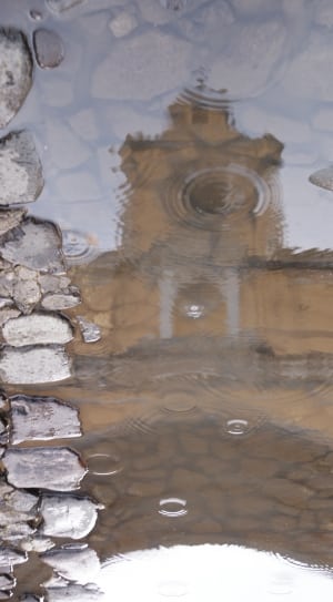 brown and concrete building reflecting body of water photo thumbnail