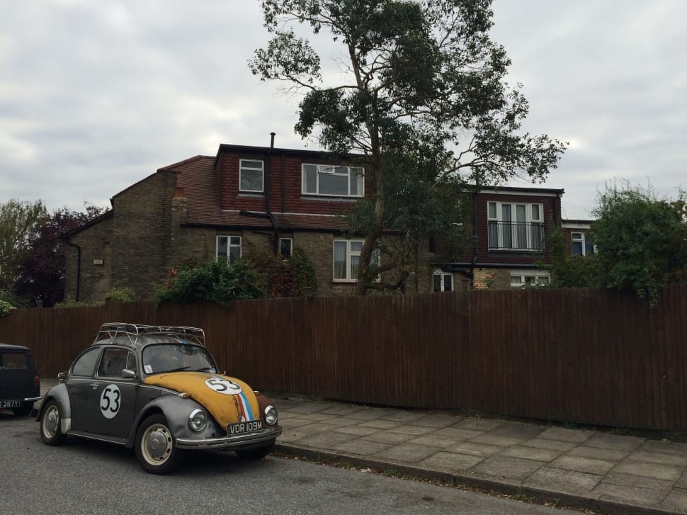 gray and orange beetle car and brown concrete two storey house preview