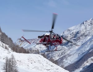 red and black helicopter near glacier mountain thumbnail