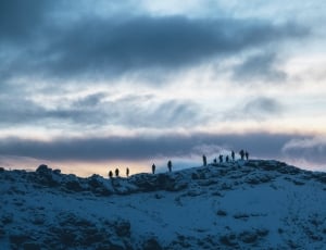 group of person on top of snow covered mountain thumbnail
