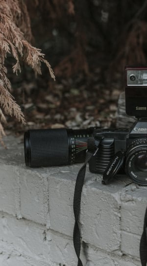 selective focus photography of black canon dlsr camera set on gray surface thumbnail