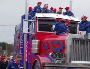 group of people riding on top of red Optimus Prime thumbnail
