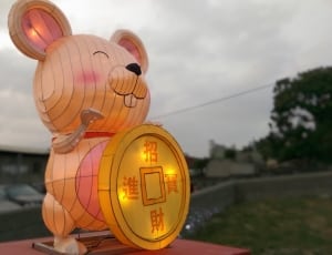brown and black mouse with fortune coin statue thumbnail