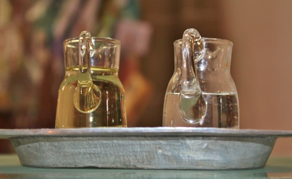 two clear glass pitcher with liquid in gray serving tray preview