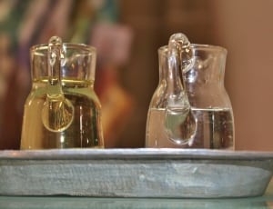 two clear glass pitcher with liquid in gray serving tray thumbnail