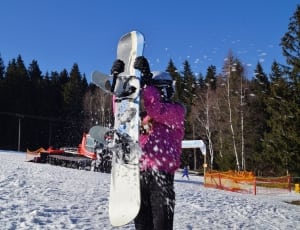 human holding snowboard on snowfield thumbnail