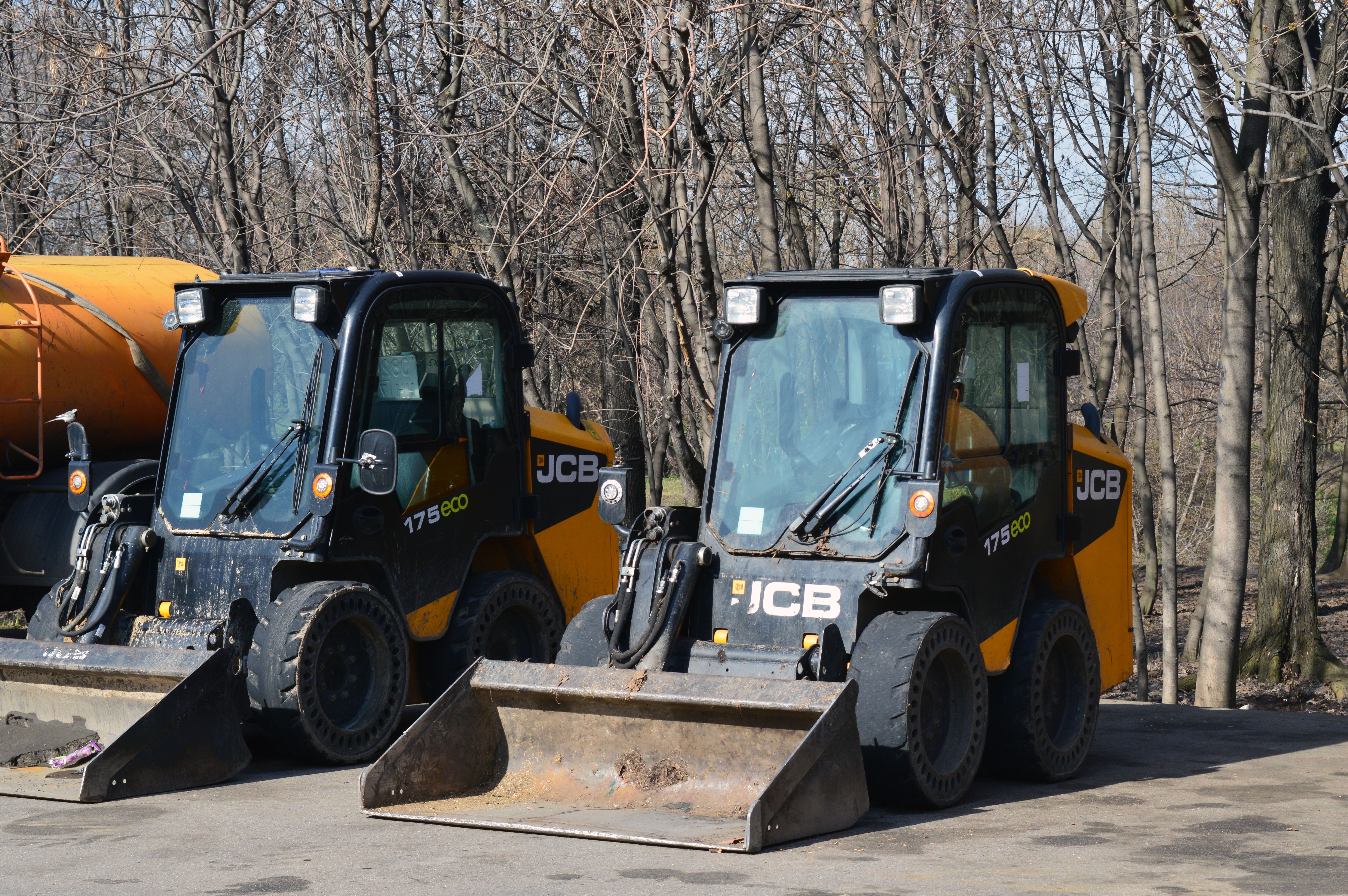 2 black and yellow jcb skid loaders