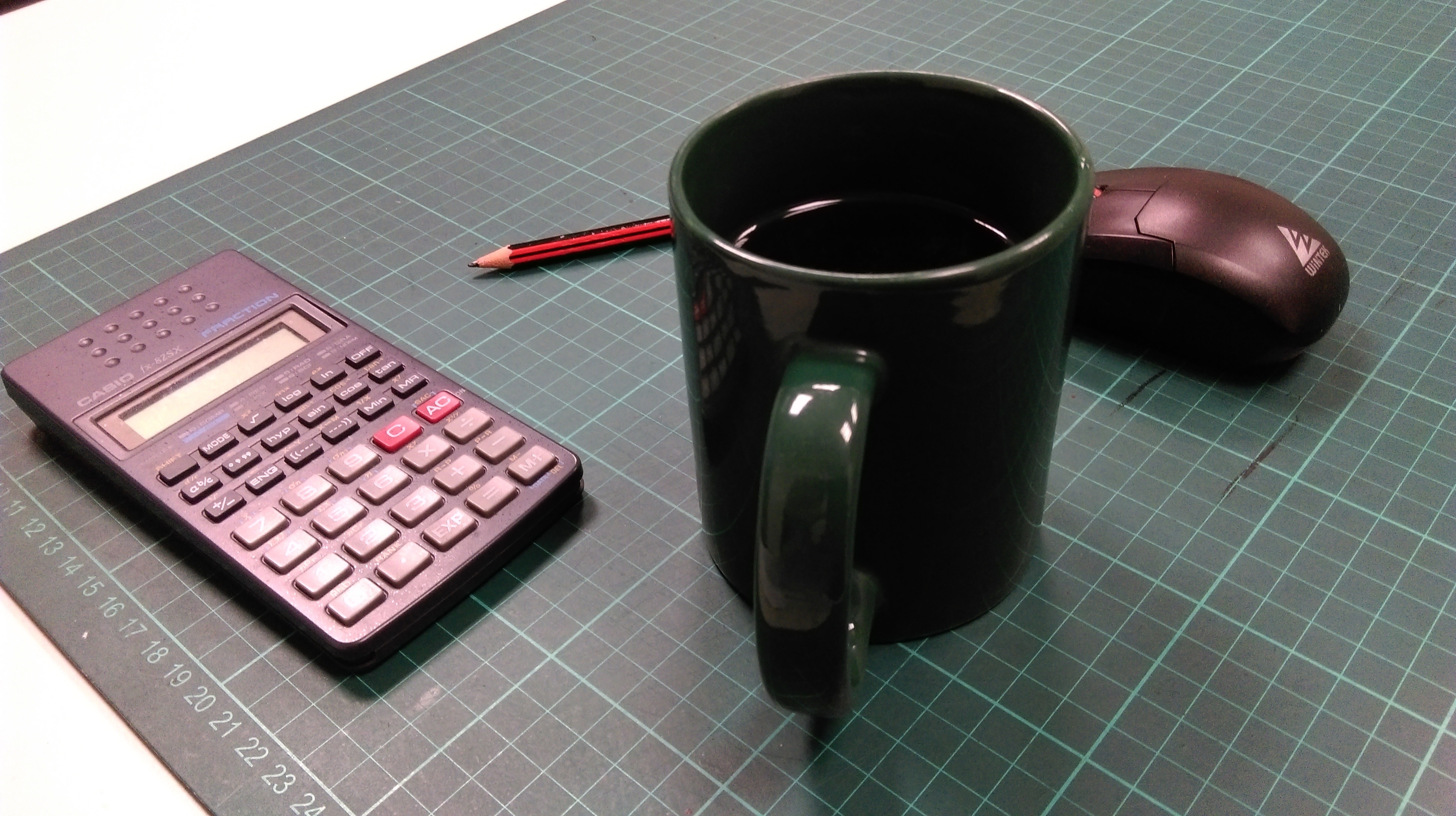 green ceramic mug and calculator