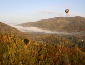 hot air balloon over grassy mountain thumbnail