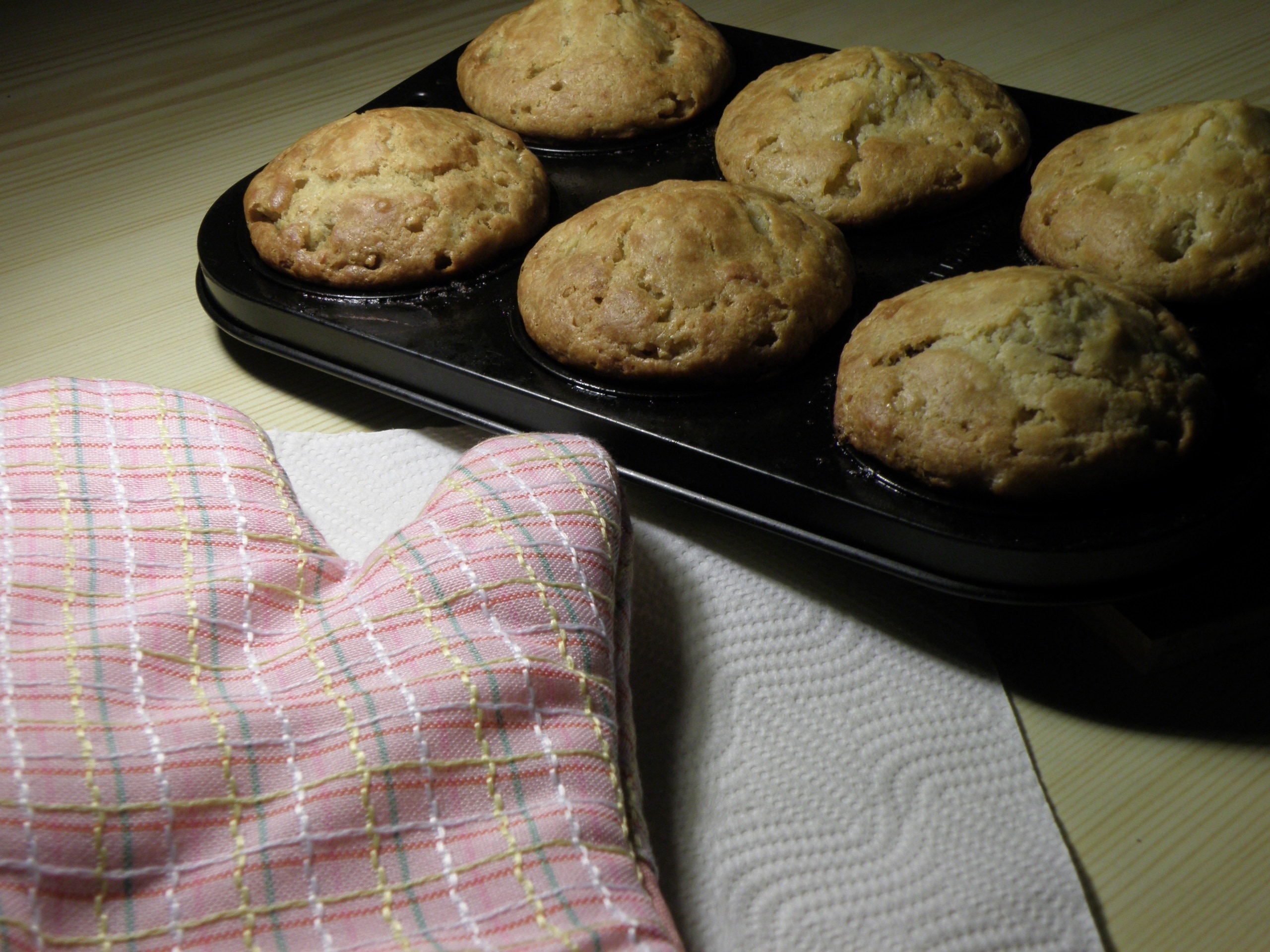 muffin in baking tray near pink mitten