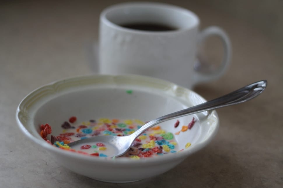 multi-colored ceramic bowl with stainless steel spoon and ceramic cup with black liquid preview