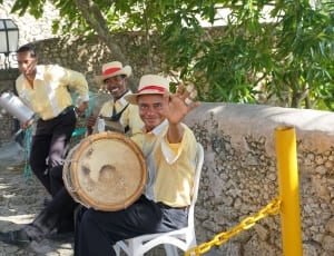 three men wearing yellow and white dress shirts playing musical instrument thumbnail