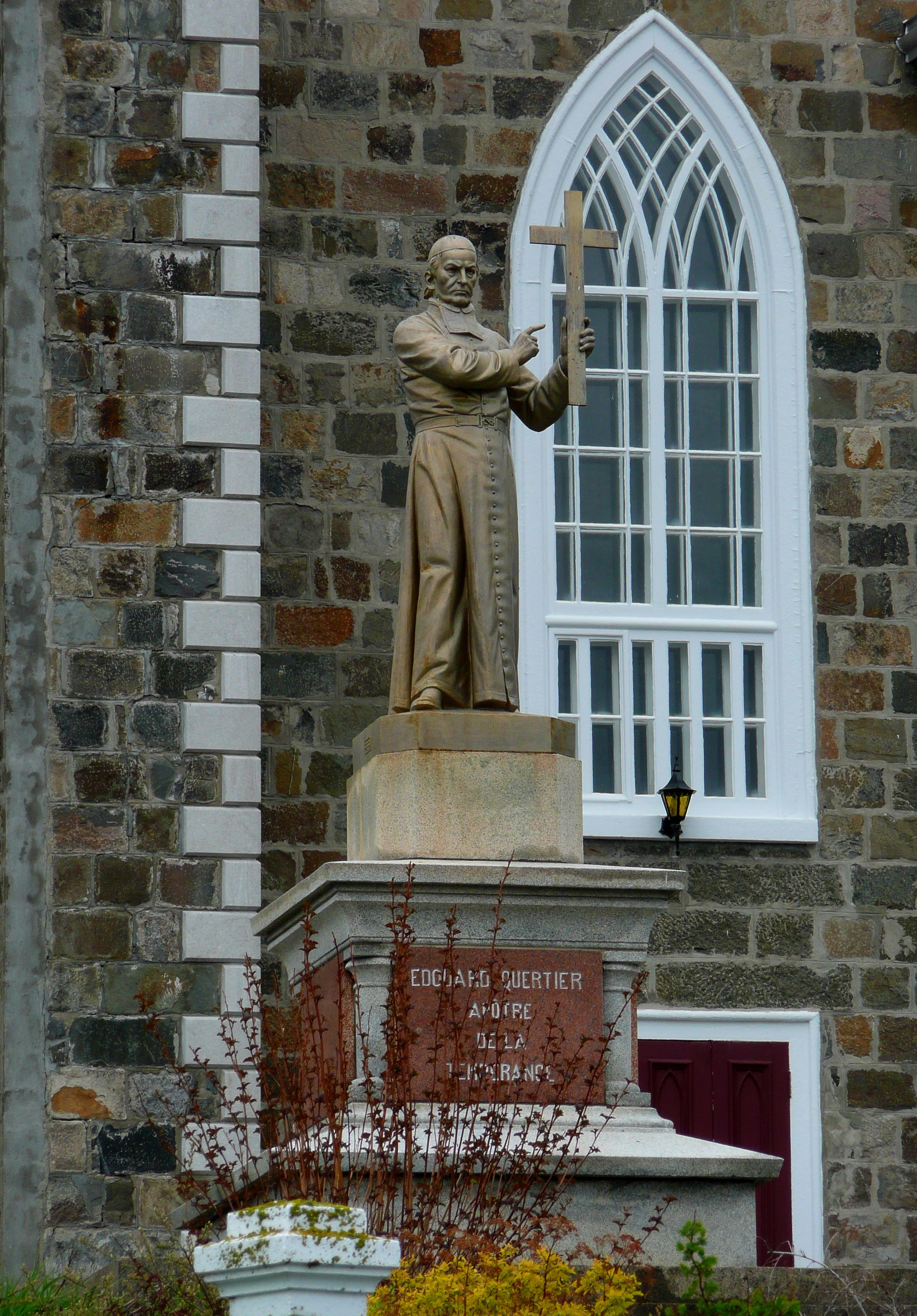man with cross brown stone statue