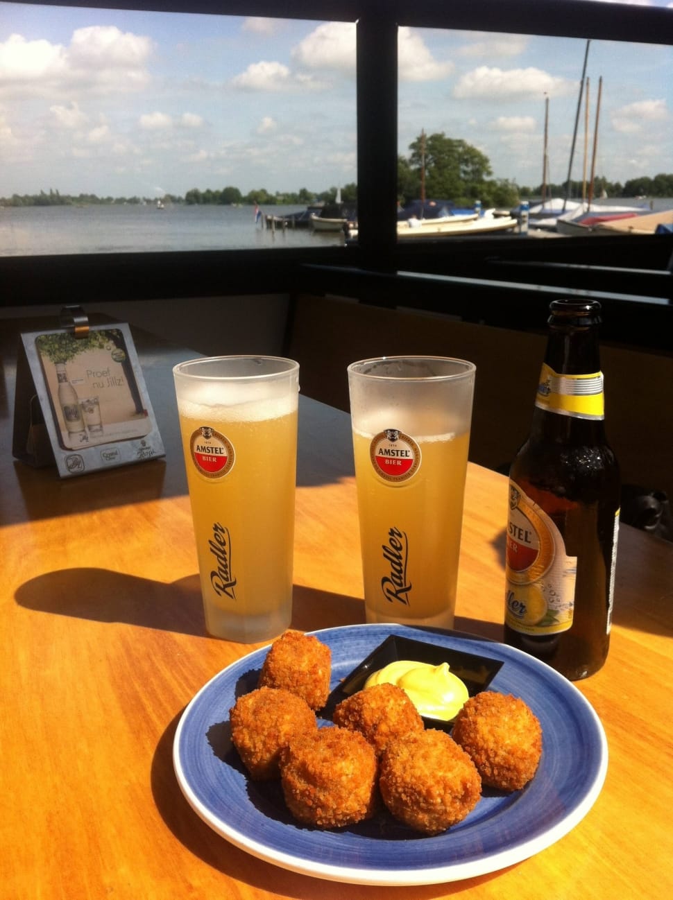 brown fritters with mayo mustard sauce with glasses of beers on side preview