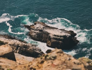 gray rock formation at blue sea during daytime thumbnail