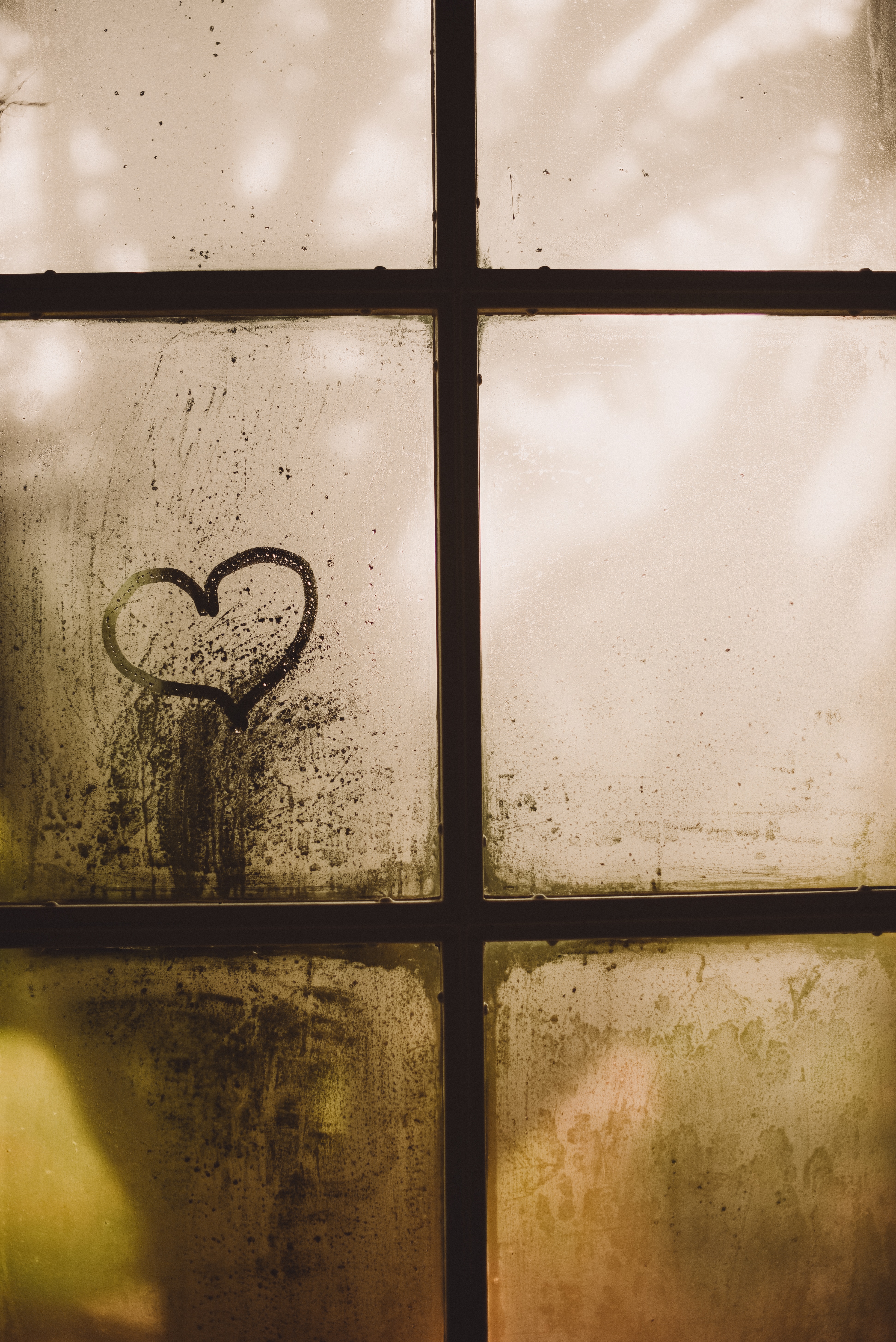 black metal window frame with heart drawing on glass