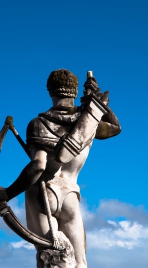 man holding bow statue during daytime thumbnail