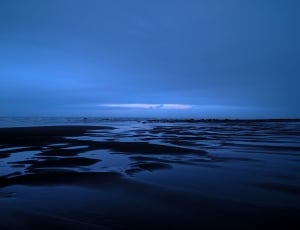 body of water under gray clouds thumbnail