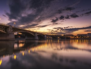 gray bridge on body of waters during sunset thumbnail