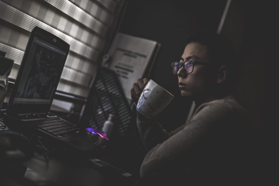 a woman is holding a mug watching movie in her laptop preview
