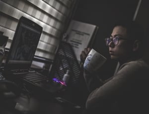 a woman is holding a mug watching movie in her laptop thumbnail