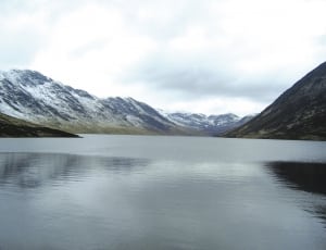 landscape photography of calm body of water near mountain range thumbnail