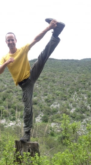 man doing yoga posture on top of log thumbnail