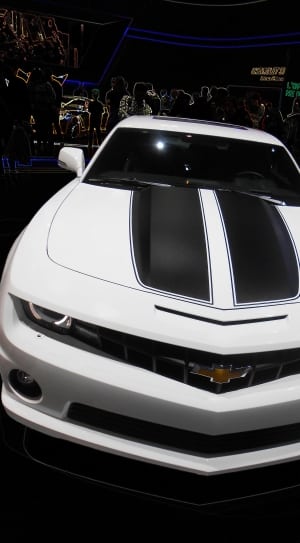 white and black Chevrolet Camaro with people gathering at motor show thumbnail