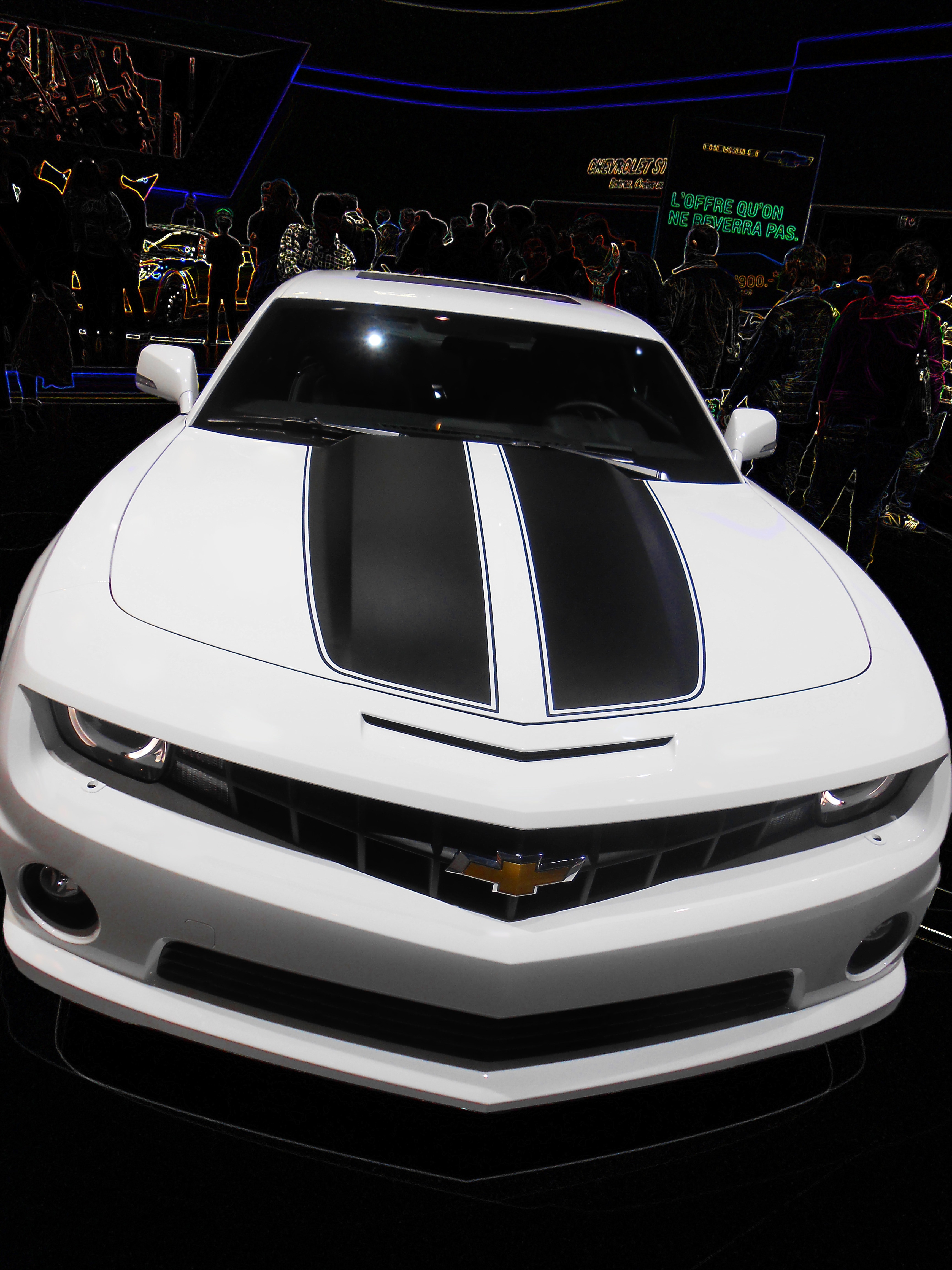 white and black Chevrolet Camaro with people gathering at motor show