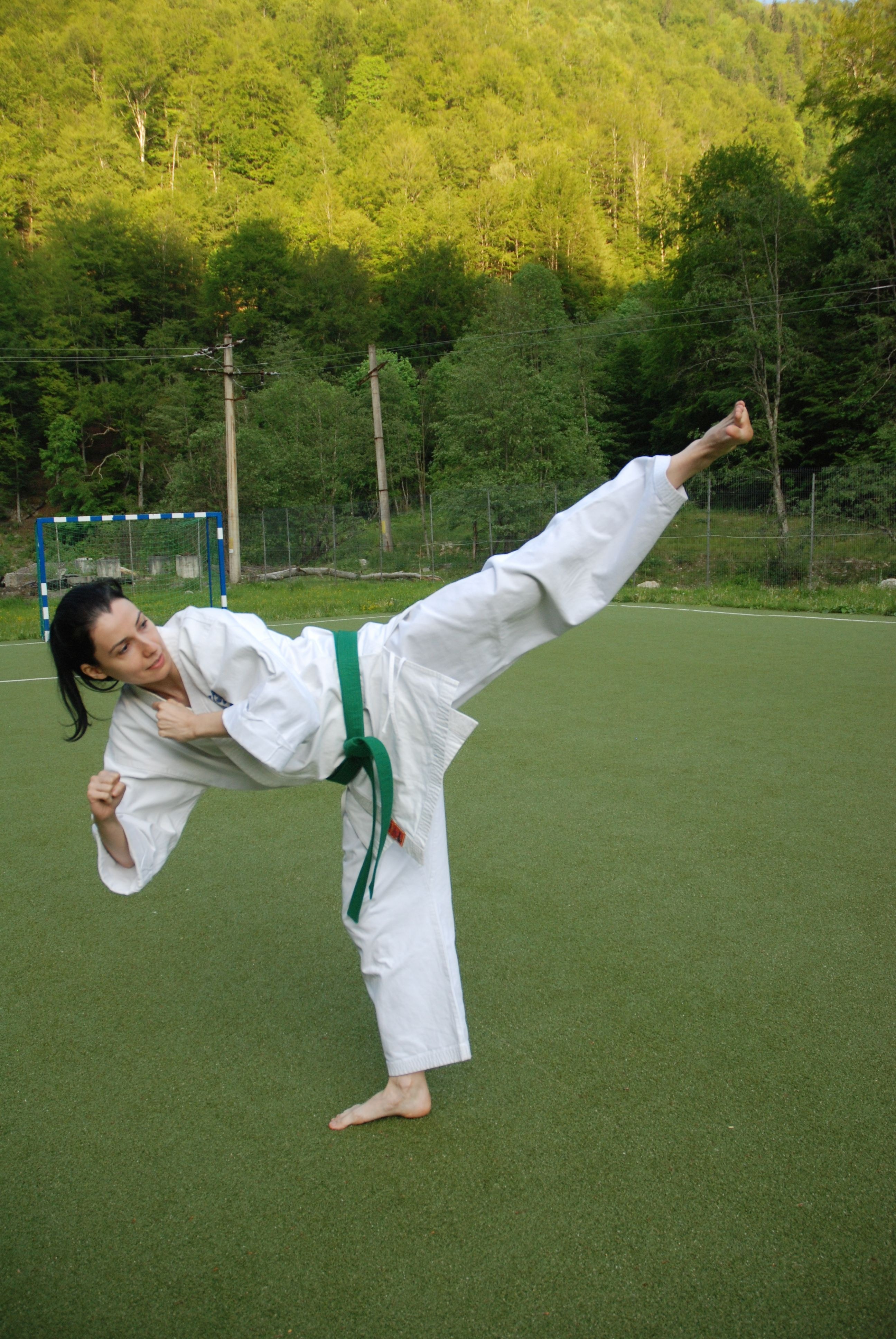 woman doing karate high kick during daytime