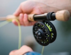 person holding black and brown fishing rod thumbnail