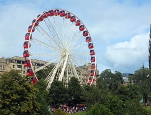 white metal framed ferris wheel with red compartments thumbnail
