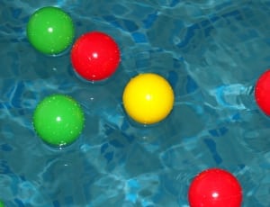 assorted rubber balls on body of water thumbnail