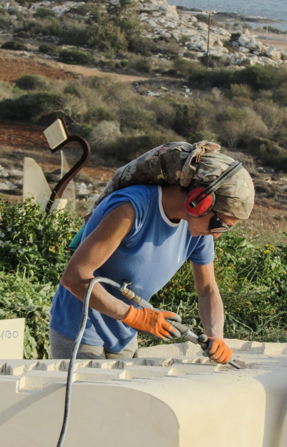 man in blue shirt and grey bottom holding grey power tool during daytime preview