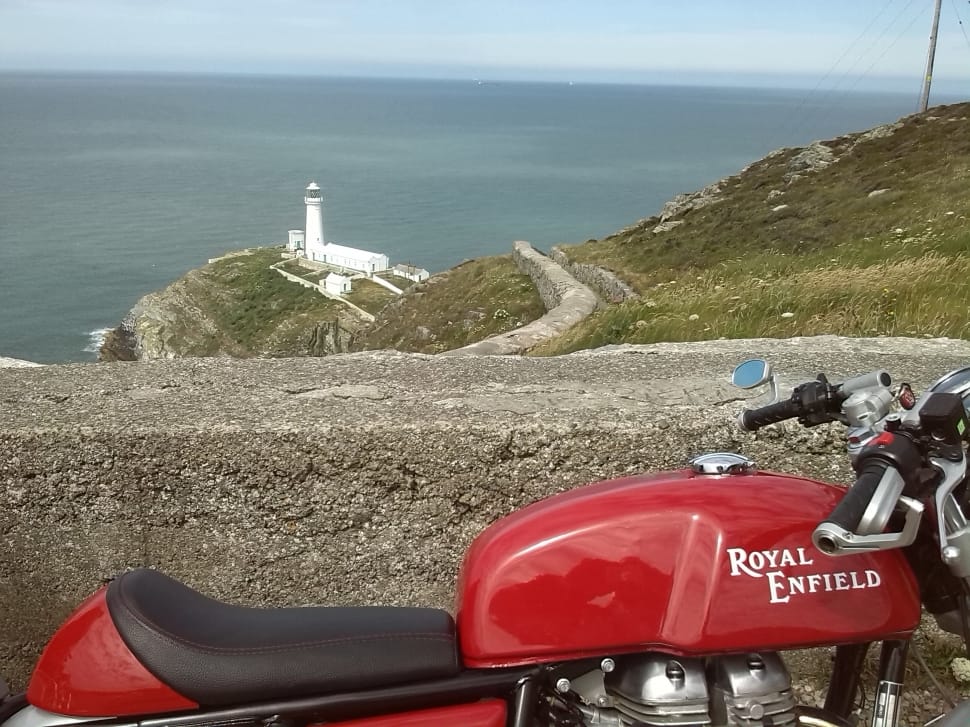 red royal enfield standard motorcycle and white lighthouse preview